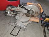 a machine that is sitting on the ground next to a red bucket