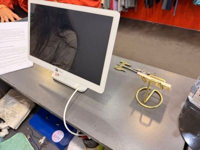 un écran d'ordinateur posé sur un bureau, avec une paire de ciseaux à côté