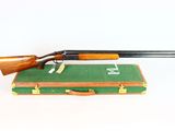 an old rifle sitting on top of a green suitcase