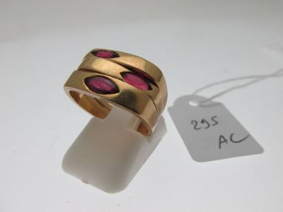 une image représentant une bague en or sertie de pierres roses sur un fond blanc