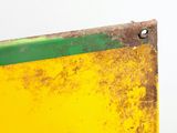 a close up of a yellow and green sign on a white wall
