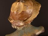 a ceramic sculpture of a woman with a hat on her head