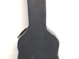 a black guitar case sitting on the floor next to a white wall