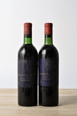 two bottles of wine sitting on top of a table next to each other