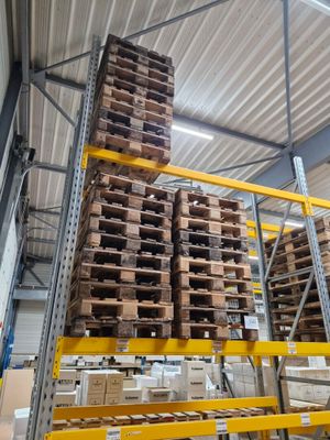 une grande quantité de palettes empilées dans un entrepôt