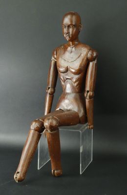 statue d'une femme assise sur une chaise, sur fond noir