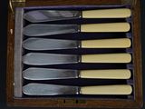 six knives in a wooden box on a black background