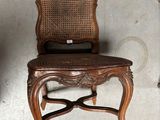 une chaise en bois avec un dossier et une assise en osier