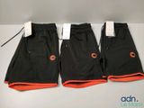 trois paires de shorts noirs et orange avec des bordures orange