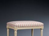 a white bench with a striped upholstered seat and legs