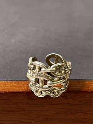 bague en argent sterling posée sur une surface en bois avec un fond gris