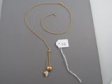 gold plated necklace with a gold ball and a white cord