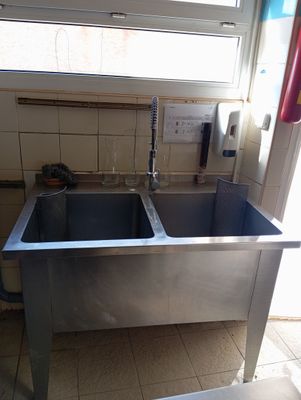 a stainless steel sink in the corner of a kitchen