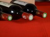 several bottles of wine are lined up on a red table