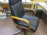 a black leather office chair in front of a computer desk