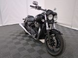 une moto noire garée sur un sol à damier