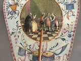 a fan with a painting on it sitting on a table