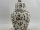 a large vase with a lid sitting on a table