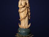a carved ivory figurine of a woman holding a child