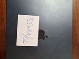 an apple laptop with a sticker on it sitting on a table