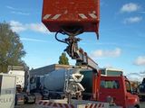 a red truck with a cement mixer on the back of it