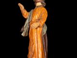 wooden statue of jesus holding a cross and a bible in his hand