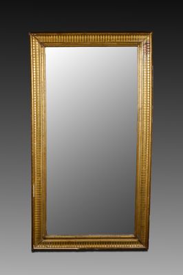 un grand miroir ancien dans un cadre doré, sur fond noir