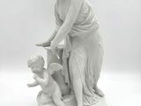statue d'une femme avec un enfant et un oiseau, posée sur un socle