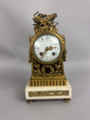 une horloge en or surmontée d'un oiseau