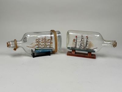 two miniature ships in a bottle with a wooden base