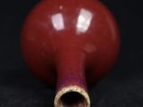 a close up of a red vase on a black surface