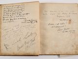 an old book with writing on it sitting on a table
