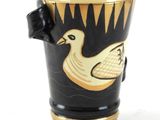 a black and gold cup with a duck on it