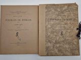 an old book with a black ribbon is open on a white surface