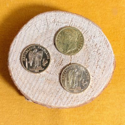 three coins sitting on top of a piece of wood