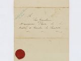 a close up of a piece of paper with a wax seal on it