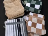quatre serviettes sont empilées les unes sur les autres sur une surface noire