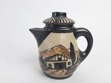 a black and white tea pot with a mountain scene on it