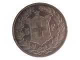 une vieille pièce de monnaie sur laquelle figure un blason sur fond blanc