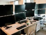 trois écrans d'ordinateur posés sur le bureau de ce bureau