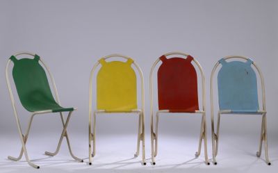 quatre chaises de couleurs différentes sont alignées sur un fond blanc