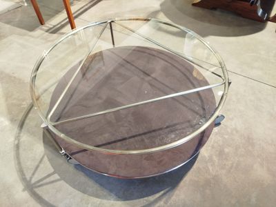 une table en verre surmontée d'un piètement métallique