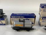 several model train cars are lined up on a white surface