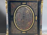 a black and gold cabinet with a clock on it