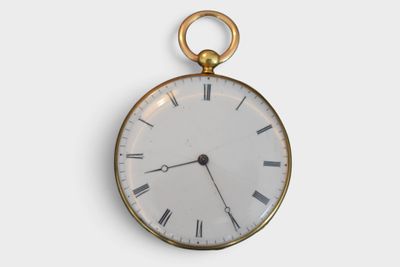 a gold pocket watch with roman numerals on the face