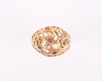 Gros plan sur une bague en or ornée de pierres roses