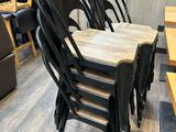 six chaises noires alignées dans un restaurant