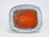 orange and blue plate with a white base on a white surface