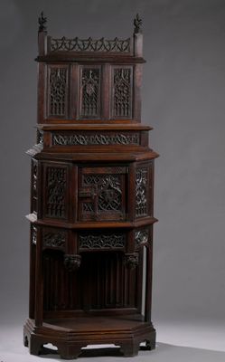 une grande armoire en bois ornée de sculptures sur le dessus