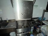a kitchen with a stove, sink, and shelves in it